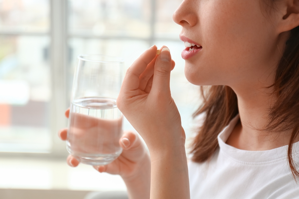 Young,Woman,Taking,Pills,At,Home