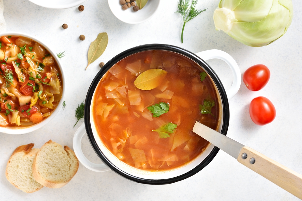 Cabbage,Soup,In,Cooking,Pot,Over,White,Stone,Background.,Top