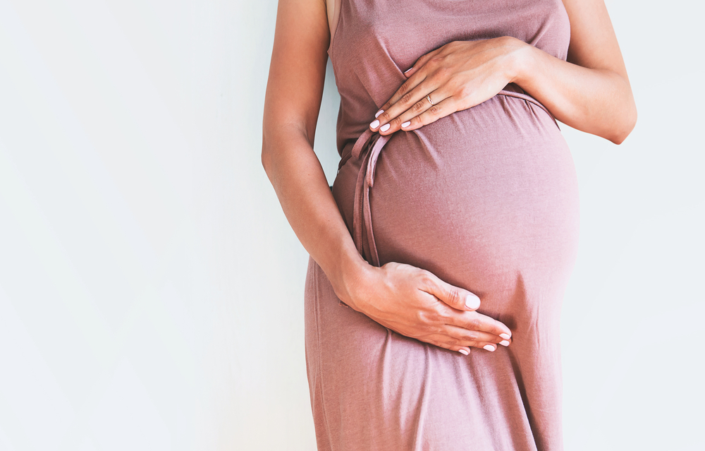 Pregnant,Woman,In,Dress,Holds,Hands,On,Belly,On,A