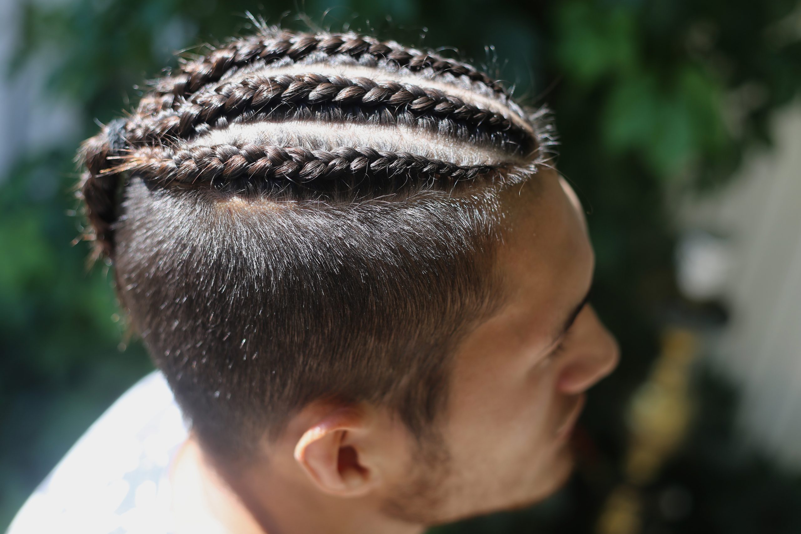 head man close-up, close-up frame of braids, hair braided into tight braids, ranks on his head, big partings