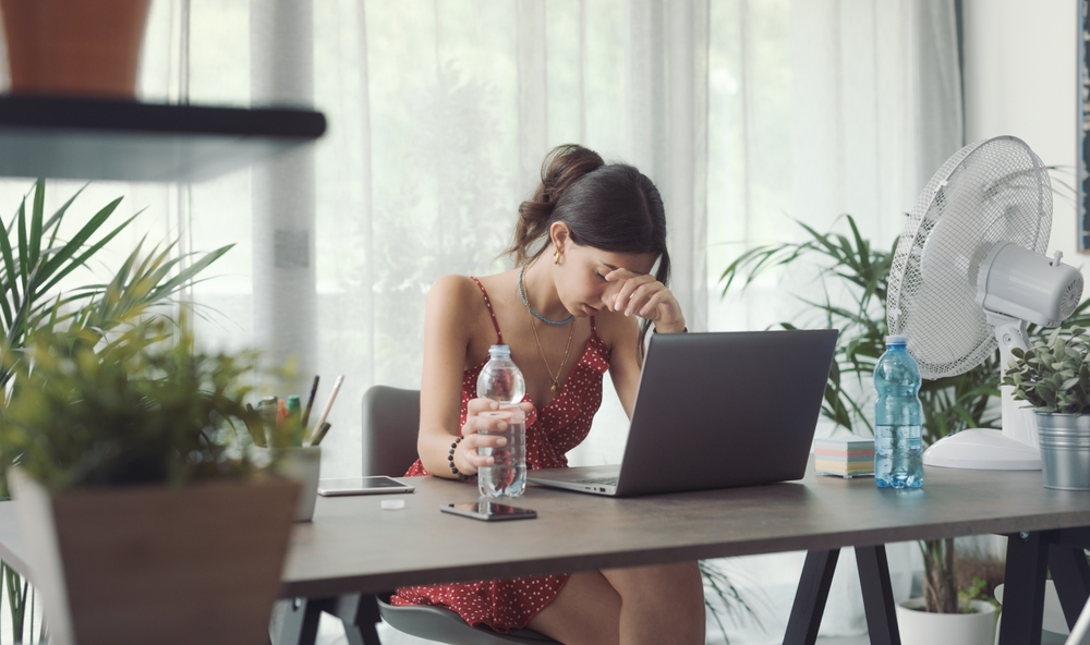 Woman,Sitting,At,Desk,At,Home,During,A,Summer,Heat