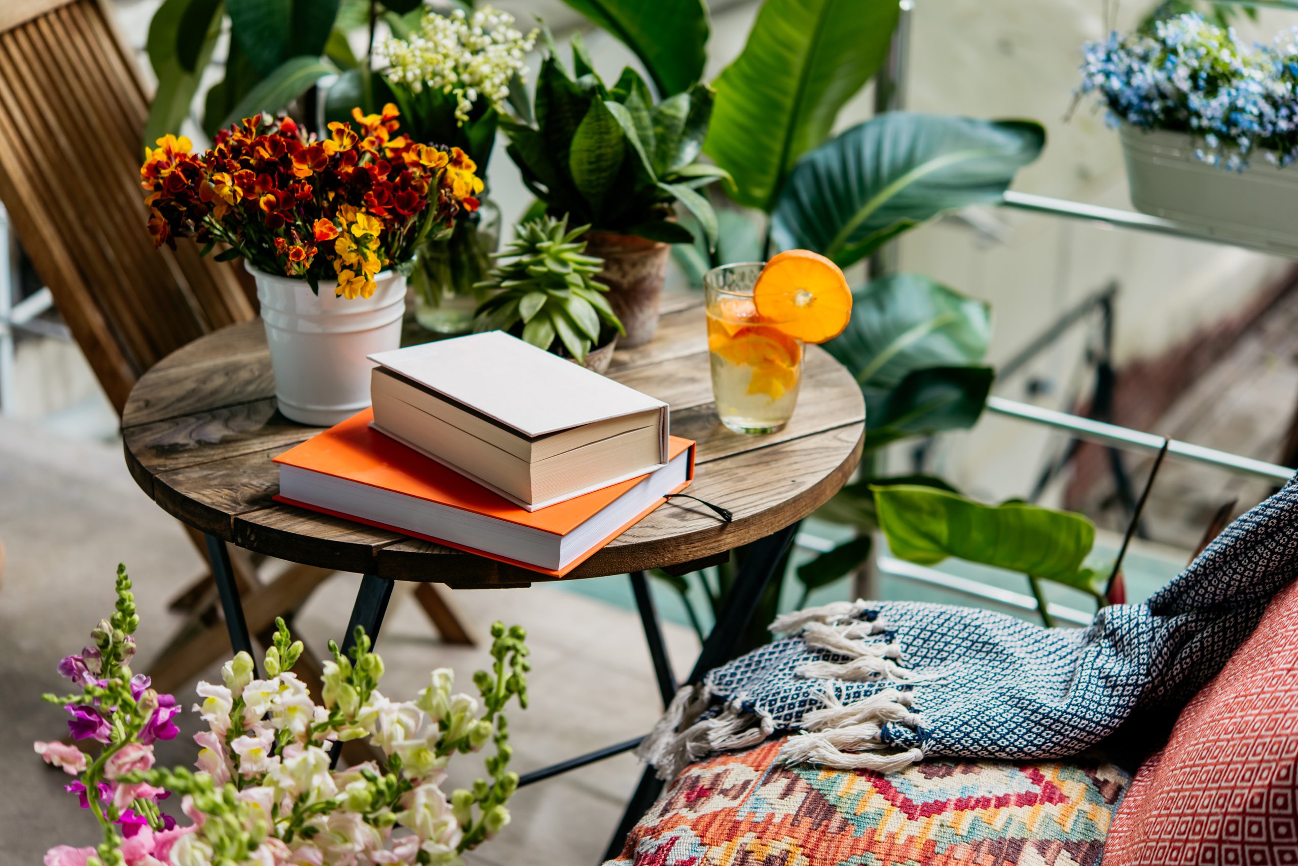 Lesen Sie im Sommer Bücher auf einer schönen Terrasse oder einen gemütlichen Balkon voller grüner Pflanzen.