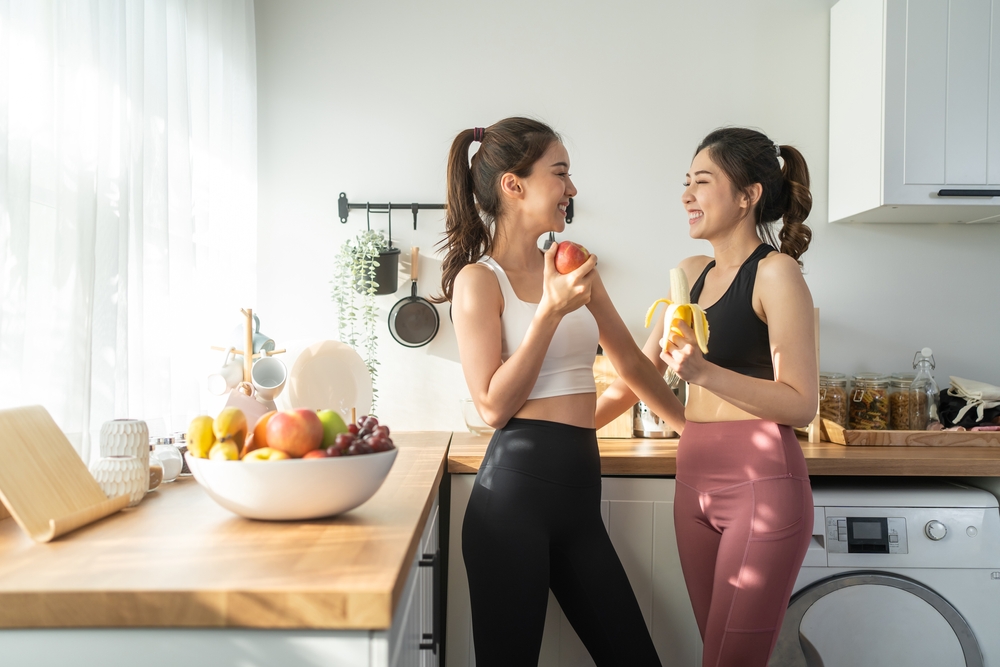 Asian,Active,Two,Women,Sibling,In,Sportswear,Eat,An,Apple