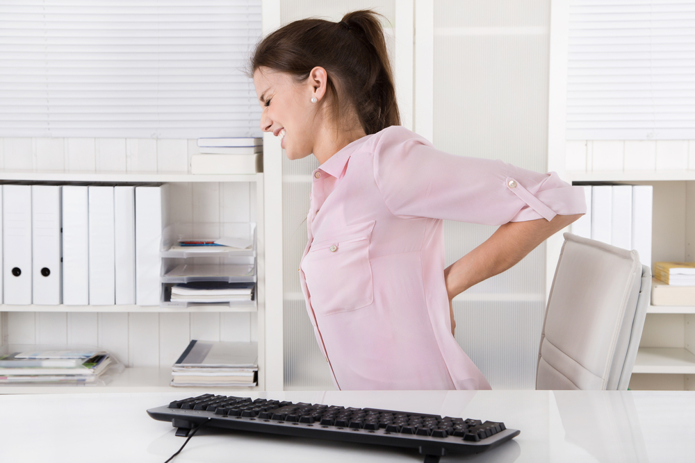 Young,Woman,Sitting,With,Backache,In,The,Office.