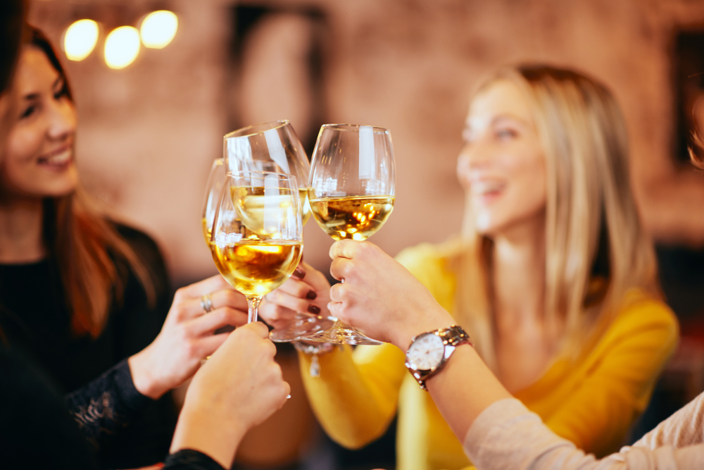 Girlfriends,Drinking,Wine,And,Chatting,While,Sitting,In,The,Bar.