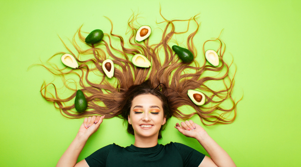Happy,Funny,Girl,Lying,On,Colored,Background,With,Avocado,Fruits