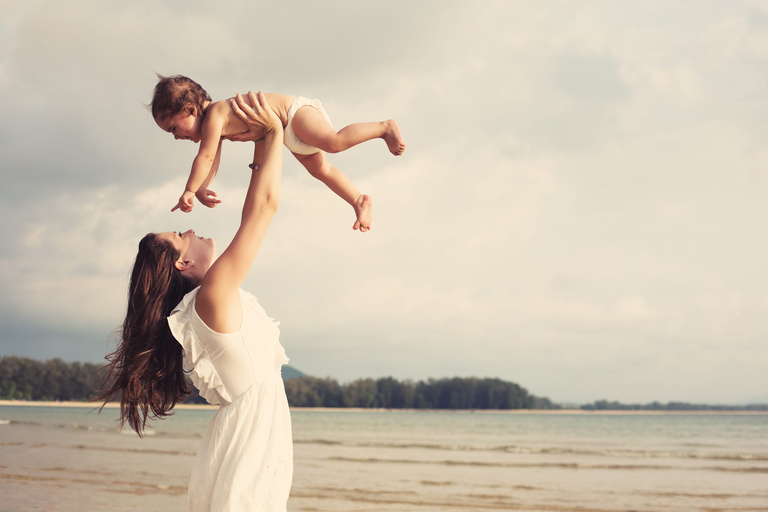 Frau am Strand mit Baby.