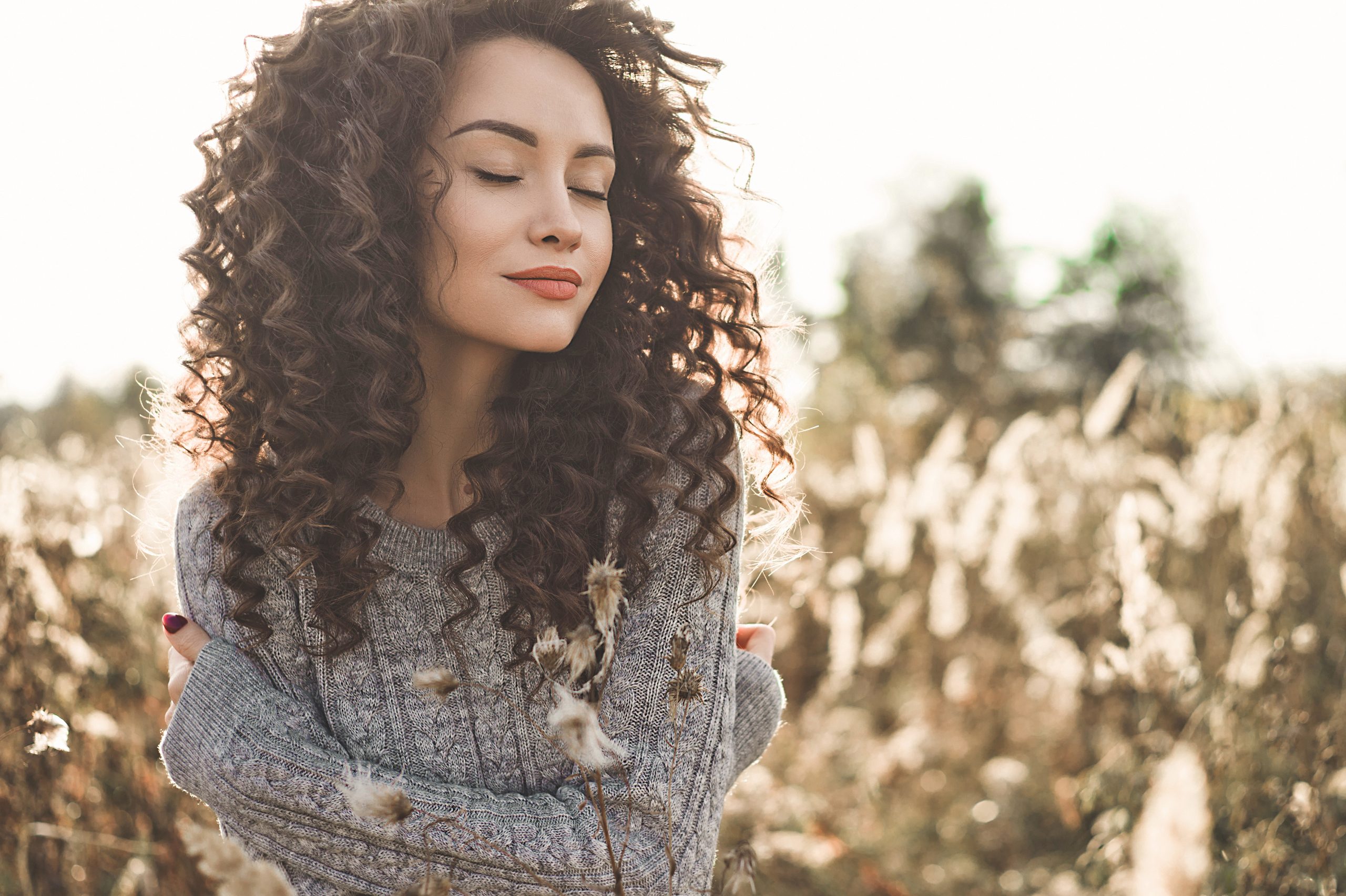Outdoor atmosphärisches Lifestyle-Foto von jungen schönen Dame. Braunes Haar und braune Augen. Warmer Fall. Herbstbesucher. Softness, Wärme und Komfort