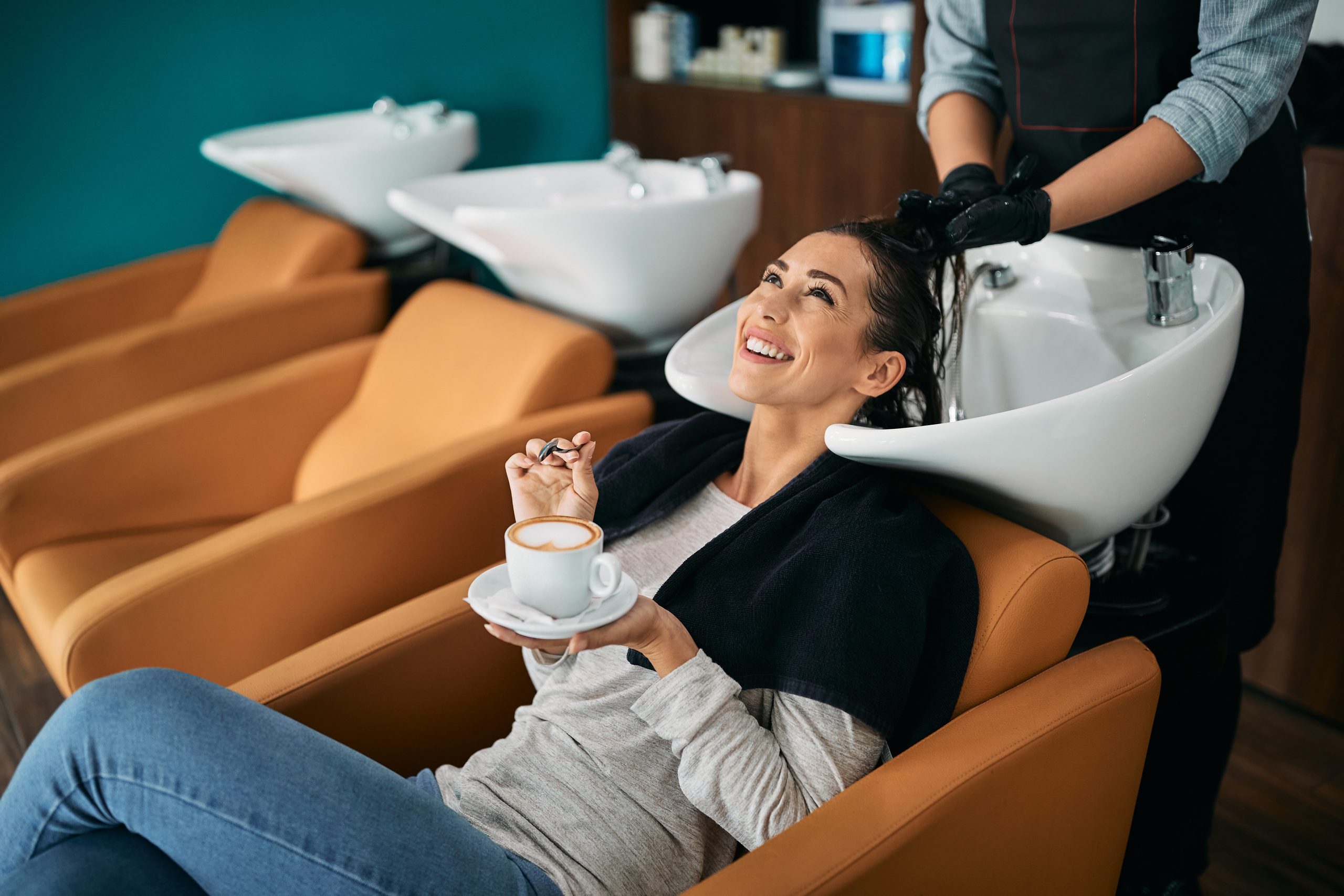 Frau beim Friseur lässt sich die Haare waschen.