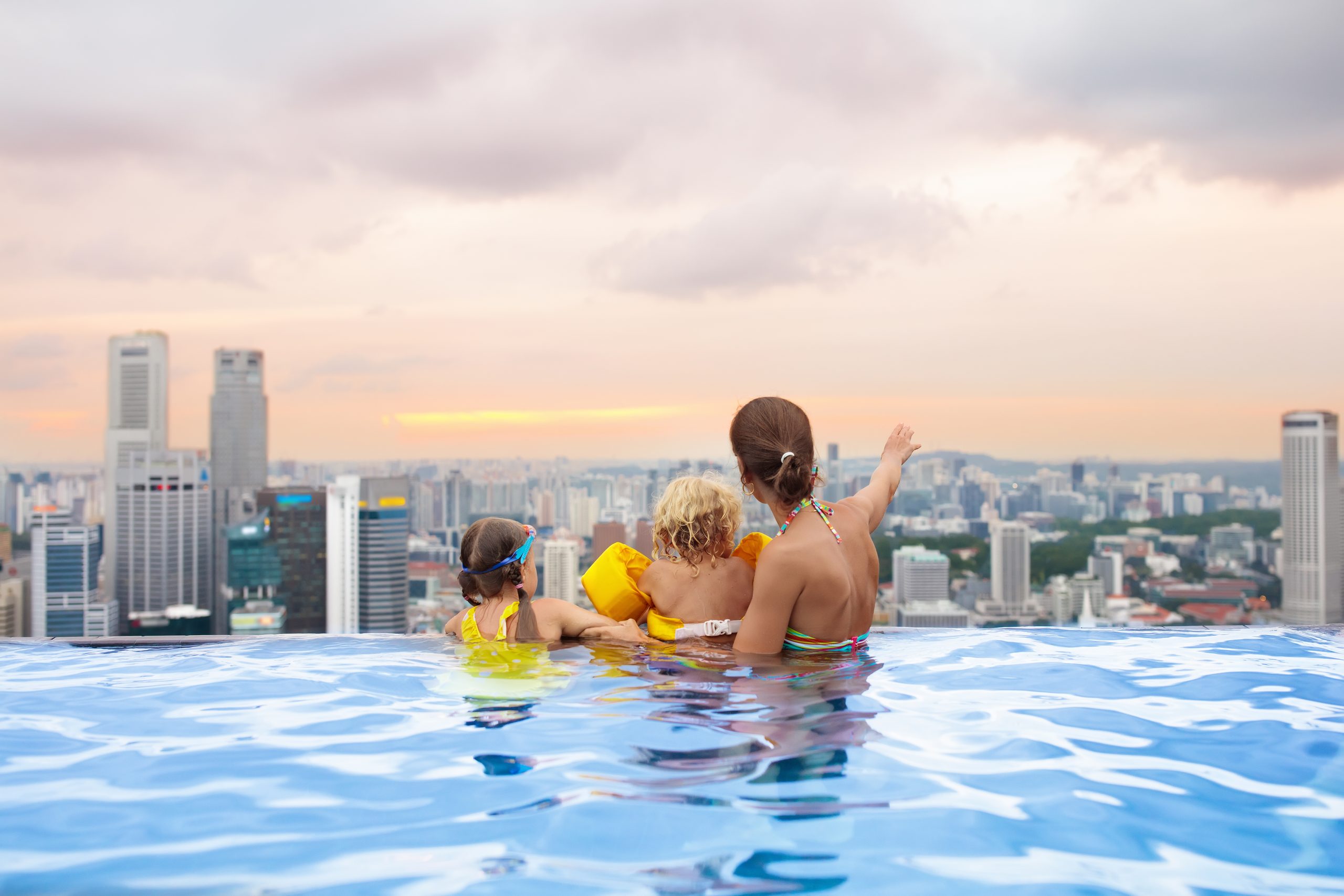 Mama mit zwei Kindern im Pool.