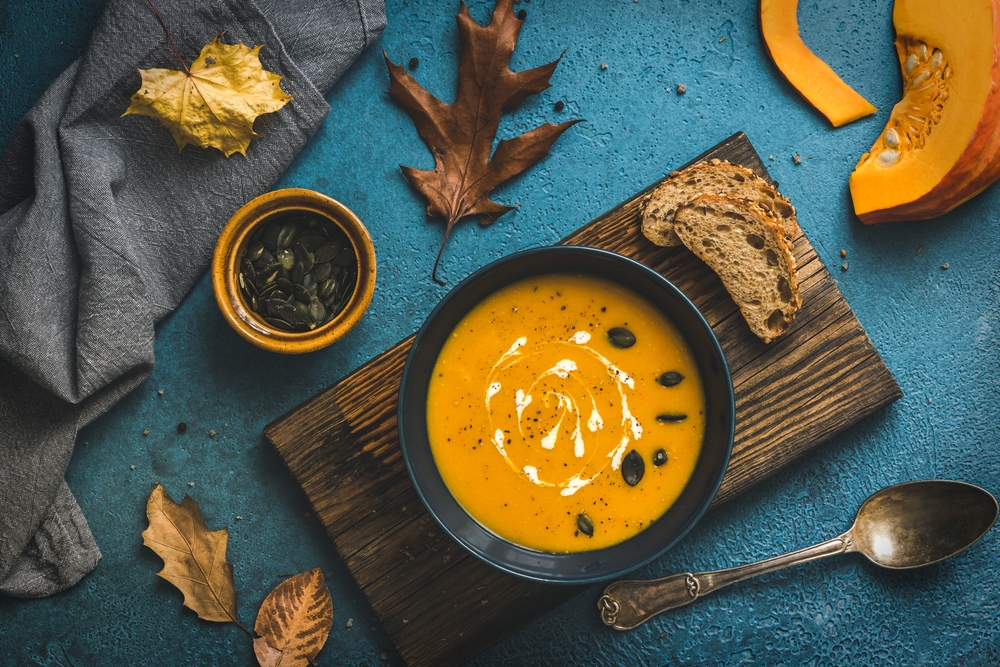 Blue,Bowl,With,Pumpkin,Soup,On,A,Rustic,Wooden,Board
