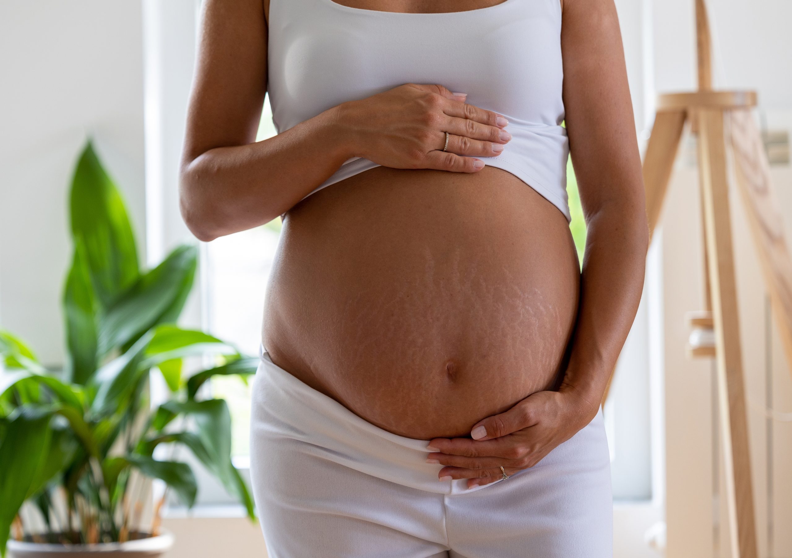 Frau hält Schwangerschaftsbauch.