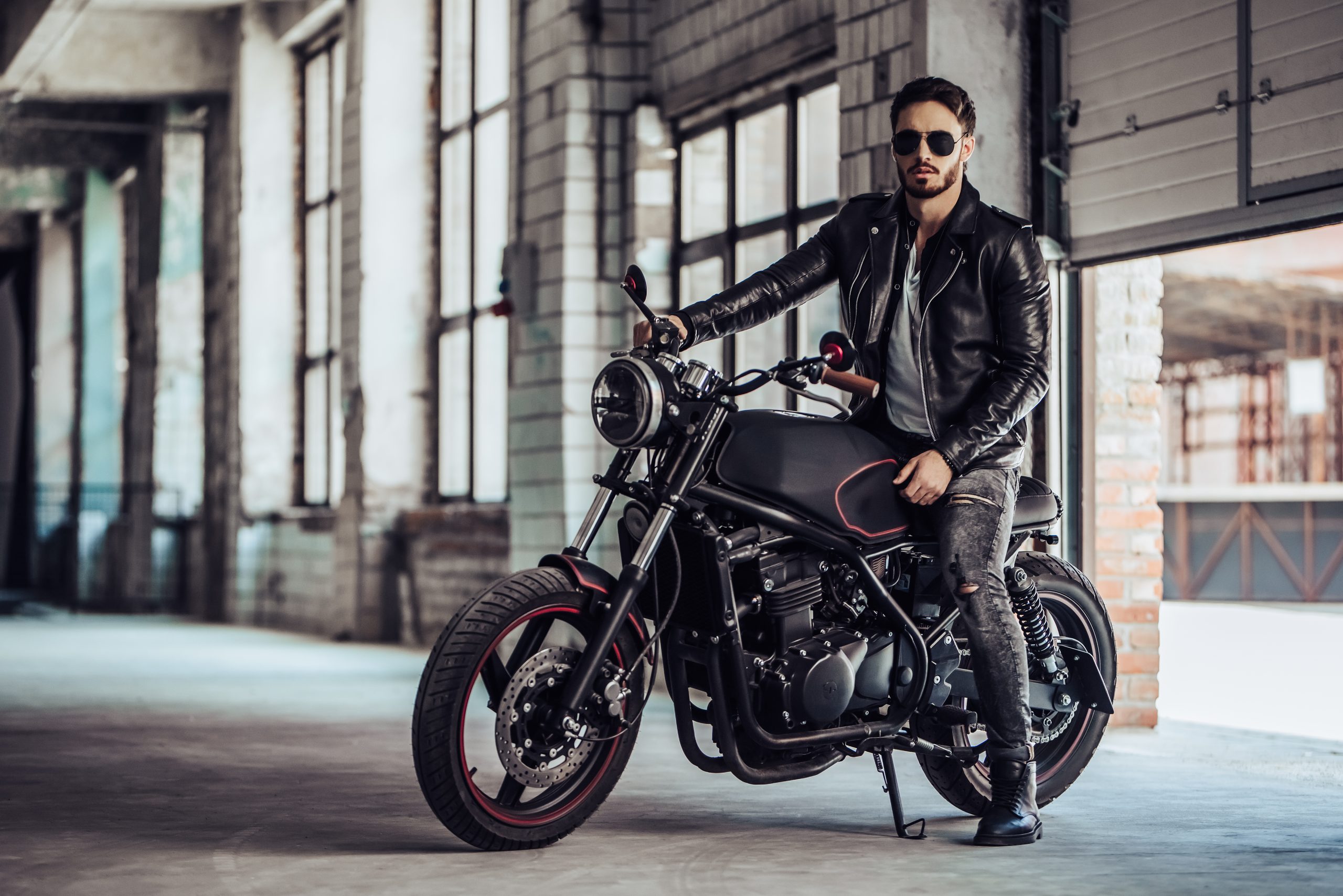 Mann, Biker auf Motorrad mit Lederjacke und Sonnenbrille