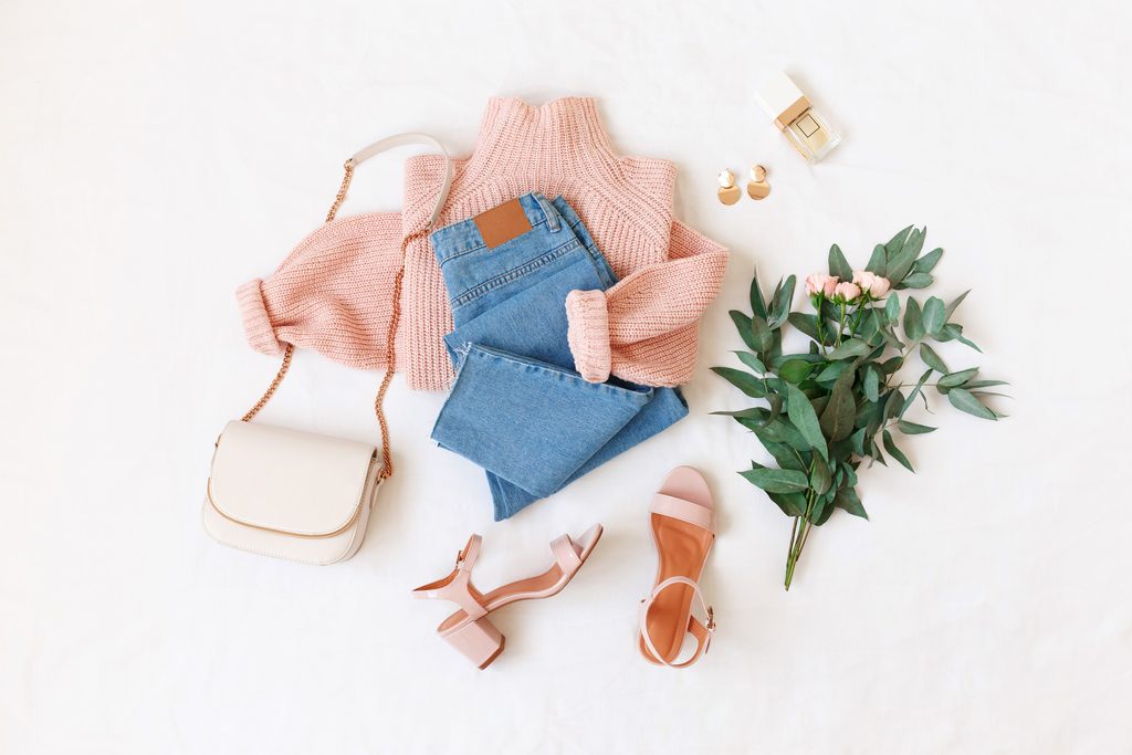 Flatlay mit Pulli, Jeans und Accessoires.